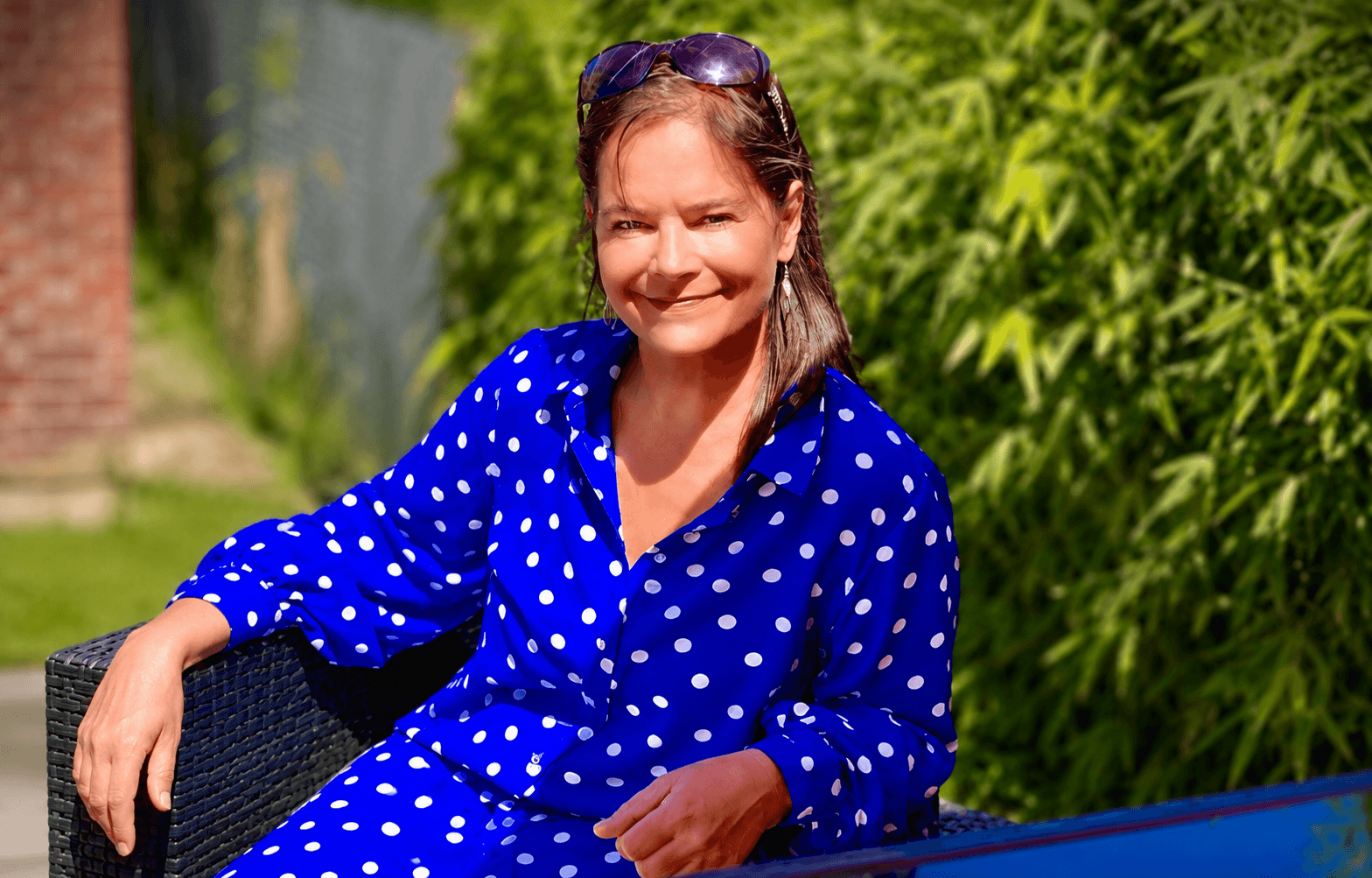 Rhian Hopkins smiling, sitting in her garden